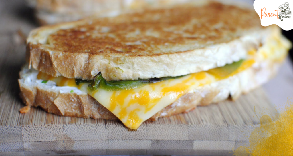 "Jalapeño Popper Grilled Cheese on a Rustic Wooden Board"
A beautifully grilled sandwich served on a rustic board, garnished with fresh jalapeño slices and a side of salad.