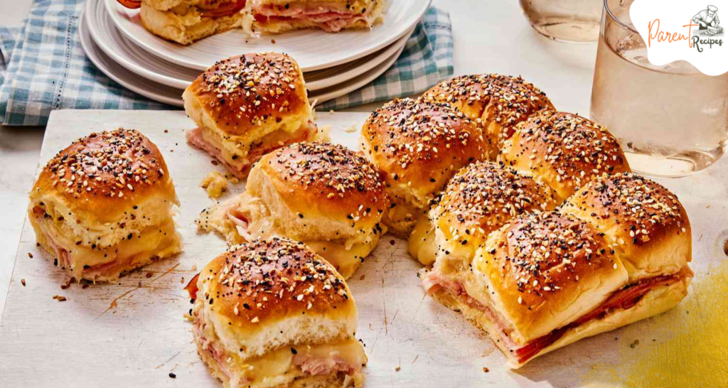 Freshly baked ham and cheese sliders in a casserole dish.